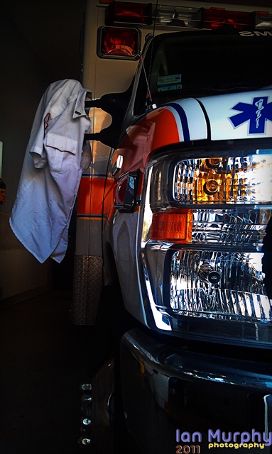 close up of ambulance with paramedic uniform hanging off side mirror